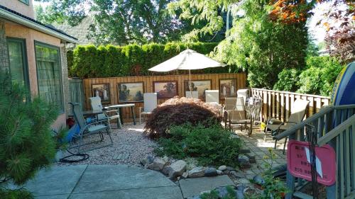 a patio with a table and chairs and an umbrella at Beds By the Bridge in Kelowna