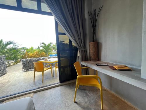 a room with a table and chairs and a balcony at Vistapaloma beach resort in Odiong