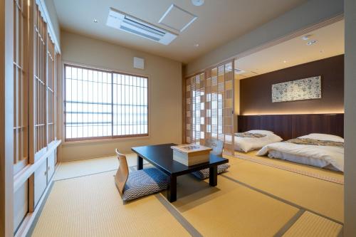 1 dormitorio con cama, escritorio y mesa en Nishiyama Ryokan - 1953年創業, en Kioto