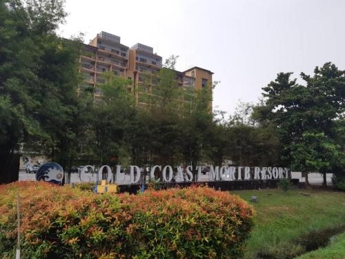 a sign in a park with buildings in the background at Relax At Gold Coast Morib in Banting