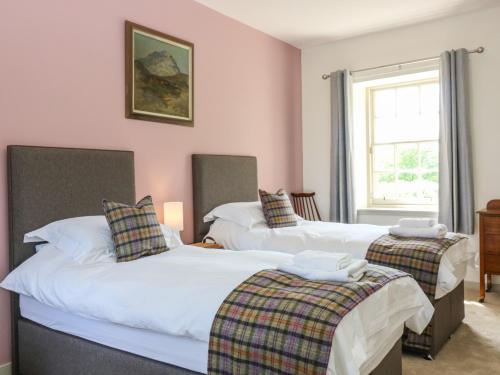 two twin beds in a room with a window at North Stables - House Of Dun in Montrose