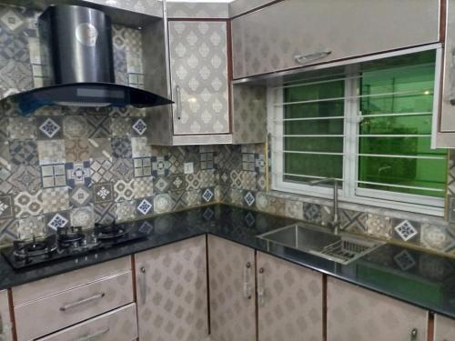 a kitchen with a sink and a stove at Furnished Private Ground Floor - Pasha House in Lahore