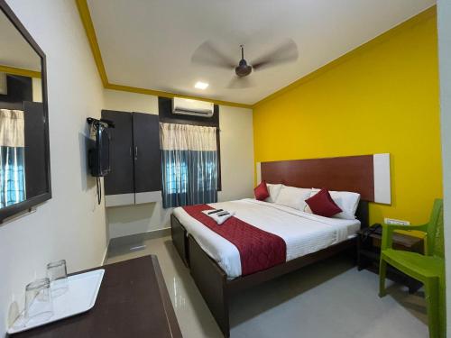 een slaapkamer met een bed en een plafondventilator bij Skyry Hotels Adyar in Chennai