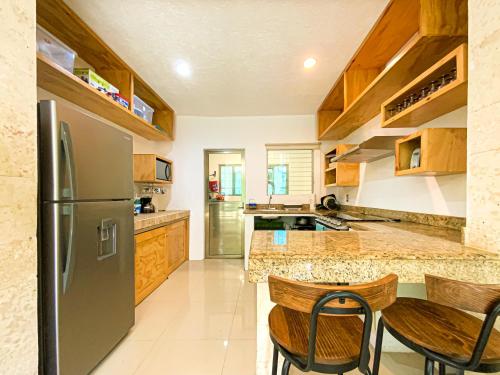 una cucina con frigorifero in acciaio inox e mobili in legno di Villa Selvática con Piscina Privada en Playa del Carmen a Playa del Carmen