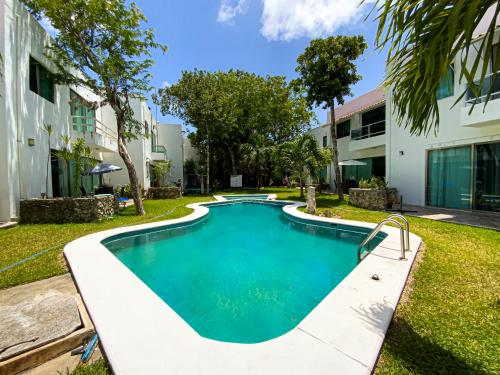 a swimming pool in a yard next to a building at Villa Selvática con Piscina en Playa del Carmen in Playa del Carmen