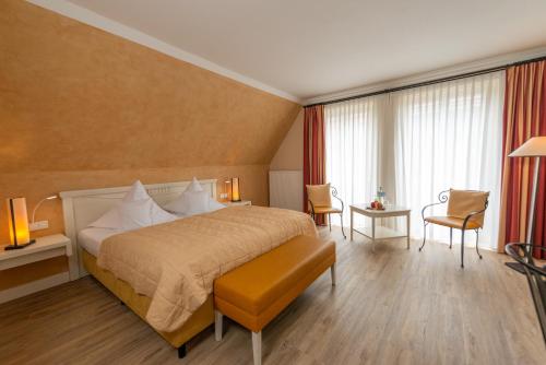 a hotel room with a bed and a table and chairs at Hotel & Restaurant Alte Schule in Siek