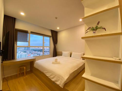 um quarto de hotel com uma cama e uma janela em Nhaanhouse Sunrise City em Ho Chi Minh