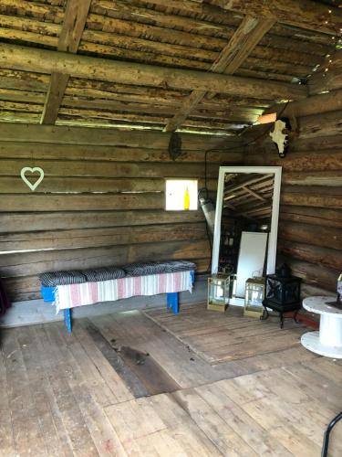 une chambre avec un banc dans une cabane en rondins dans l'établissement Glampingtält, à Torsby