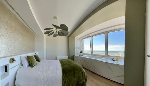 um quarto com uma cama, uma banheira e uma janela em Le Haut de Gamme Vue mer - Malo cation em Dunkerque