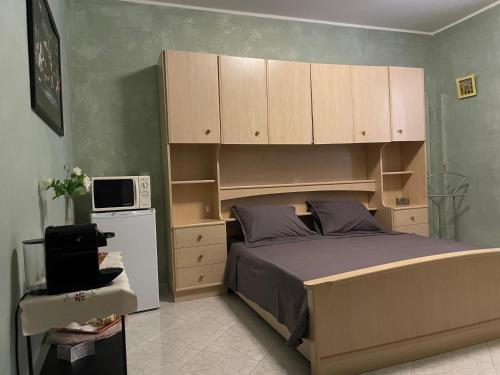 a bedroom with a large bed with wooden cabinets at Residence Don Turi in Villafranca Tirrena