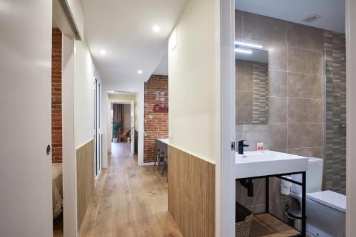 a bathroom with a white sink and a brick wall at BBarcelona Sagrada Familia Flats in Barcelona