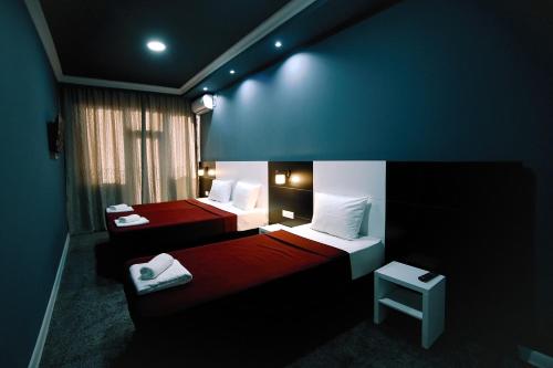 a room with two beds with red and white at Hotel Rero in Kutaisi