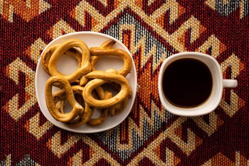 un plato de pretzels y una taza de café en Casa din "Curtea cu cai", en Borsec