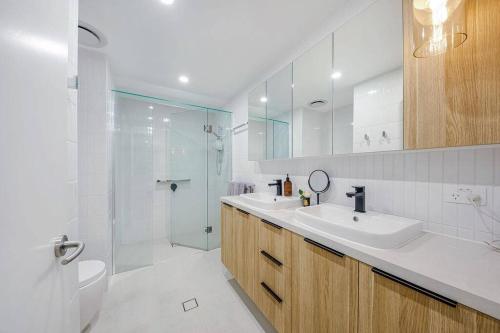 y baño blanco con lavabo y ducha. en SEASIDE ESCAPE@ The Cosmopolitan Unit 10406, en Maroochydore