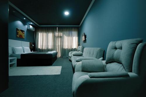 a living room with couches and chairs and a room with a couch at Hotel Rero in Kutaisi