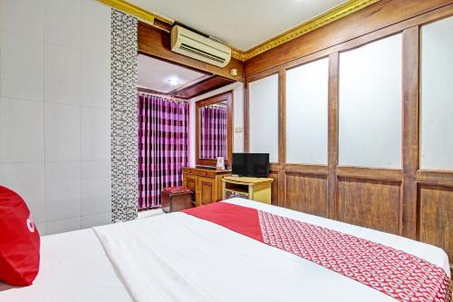 a bedroom with a bed and a tv in it at OYO 91525 Hotel Bugisan in Ngabean