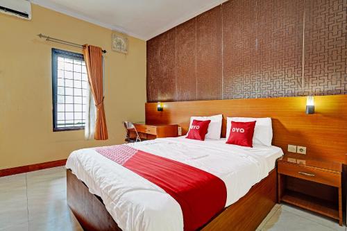 a bedroom with a large bed with red pillows at OYO 91547 Graha Hermawan Guest House Syariah in Bandung