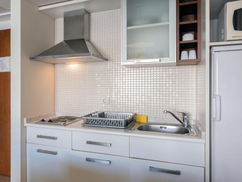 a kitchen with white cabinets and a sink at Barut B Suites in Side