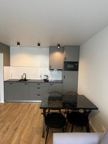 a kitchen with a table and chairs in a room at ETG Apartment in Mažeikiai