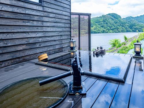 a plunge pool on a deck with a view of a lake at Kameyama Onsen Hotel in Kimitsu