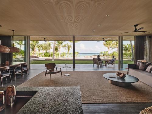 a living room with a view of the ocean at Patina Maldives, Fari Islands in North Male Atoll