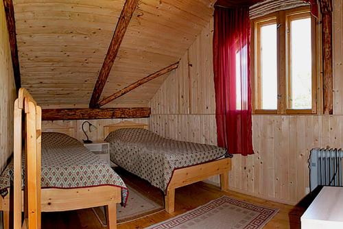 a bedroom with two beds in a wooden cabin at Yasna Sadyba in Yasenitsa Zamkova