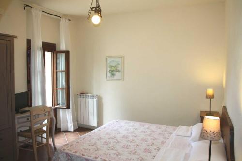 a bedroom with a bed and a desk and a chair at Agriturismo La Torretta in Siena
