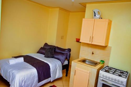 a small bedroom with a bed and a stove at Attic Place South B in Nairobi