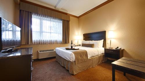 a hotel room with a bed and a television at Best Western Plus Kamloops Hotel in Kamloops