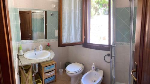 y baño con aseo, lavabo y ducha. en Villa Relax, en Santa Lucia