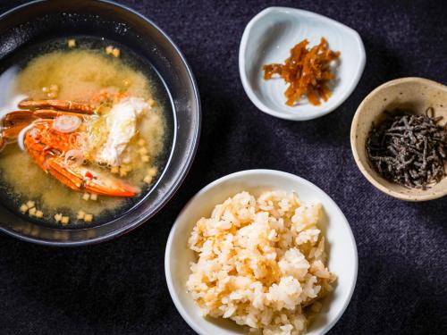 a table topped with bowls of food and rice at Kameyama Onsen Hotel in Kimitsu