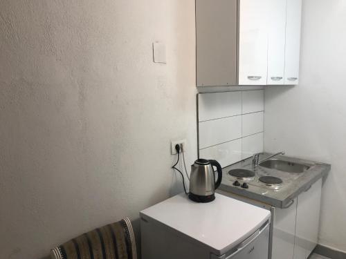 a kitchen with a tea kettle on top of a refrigerator at Apartments OldTown in Podgorica