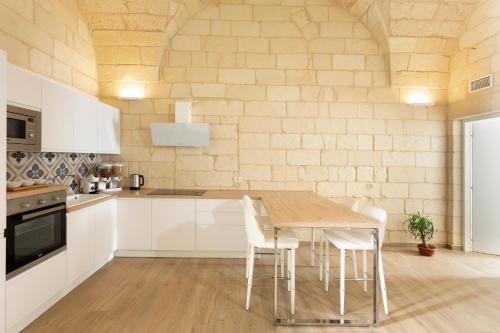 a kitchen with a wooden table and white cabinets at DonCarlo Suite Relais - Free Parking-parcheggio gratuito in Lecce