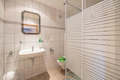 y baño con aseo, lavabo y ducha. en Ferienwohnung Storchennest en Bad Liebenstein