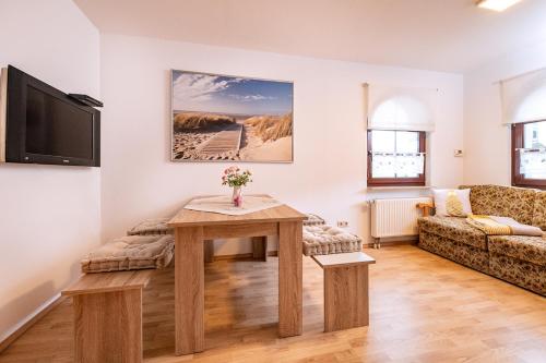 sala de estar con mesa y sofá en Ferienwohnung Storchennest en Bad Liebenstein