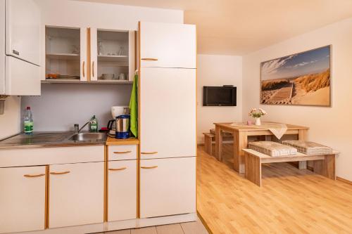 a kitchen with a white refrigerator and a table at Ferienwohnung Storchennest in Bad Liebenstein
