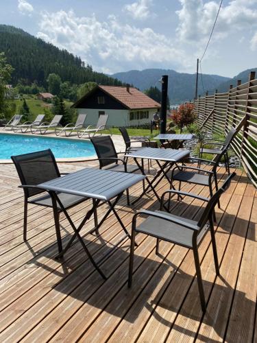 a table and chairs on a deck next to a pool at Maison La Devinière - sauna et spa compris accessibles toute l'année in Xonrupt-Longemer