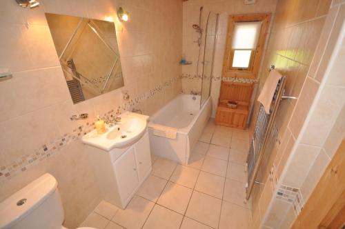 a bathroom with a sink and a tub and a toilet at Kipplochan in Dalbeattie