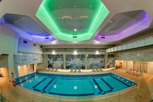 a swimming pool in a building with a ceiling at Citi Hotel's Warszawa-Falenty in Raszyn