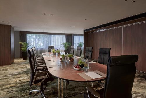 a conference room with a long wooden table and chairs at PARKROYAL COLLECTION Kuala Lumpur in Kuala Lumpur