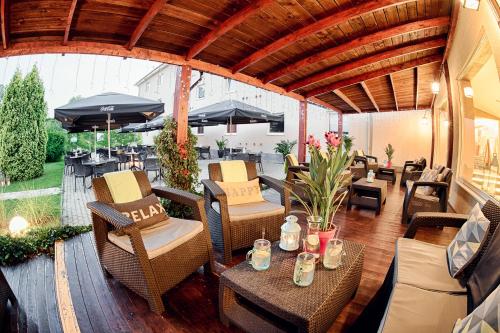 an outdoor patio with chairs and tables and umbrellas at Citi Hotel's Warszawa-Falenty in Raszyn