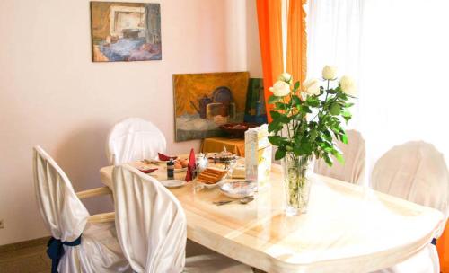 a dining room table with a vase of flowers on it at Irena Family House in Vilnius