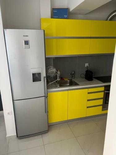 una cucina con un frigorifero bianco e mobili gialli di Vardar a Skopje