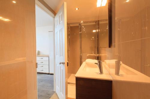 a bathroom with a sink and a shower at Wellington View: Ground floor apartment with sea views and garden in Kent