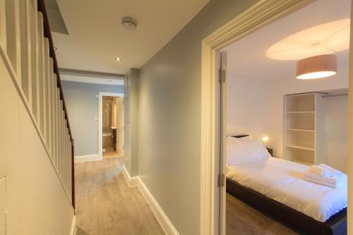 a small bedroom with a bed and a hallway at Wellington View: Ground floor apartment with sea views and garden in Kent