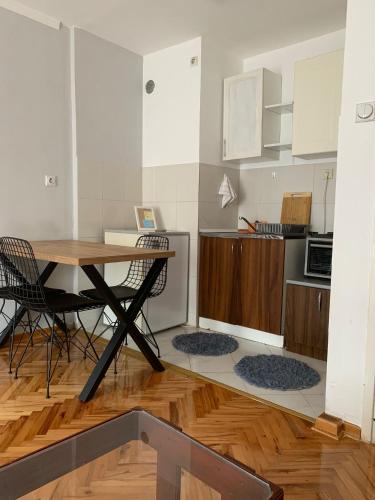 a kitchen with a table and chairs in a room at Comfy Studio - 1 minute walk to Delta Planet in Niš