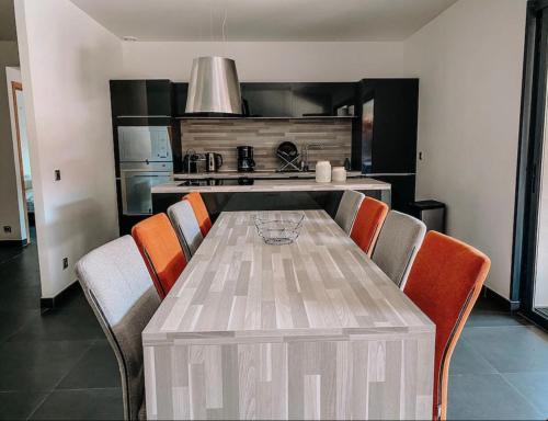 - une cuisine avec une table, des chaises et une cuisinière dans l'établissement CASA GIABICONI Villa 12 personnes piscine & spa, à Sainte-Lucie de Porto-Vecchio