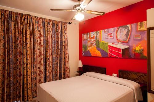 a bedroom with a bed and a red wall at El Cid in Sitges