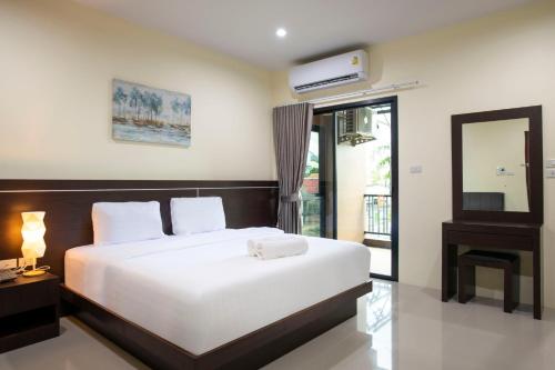 a bedroom with a large white bed and a mirror at Thip Thip Hotel in Ban Khlong Chi Lat