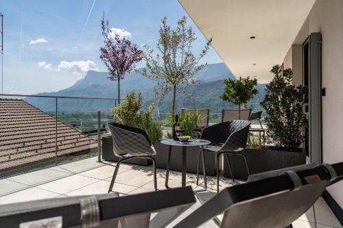 a balcony with chairs and a table with a view at Videre Penthouse Lodge exclusive in Gargazzone